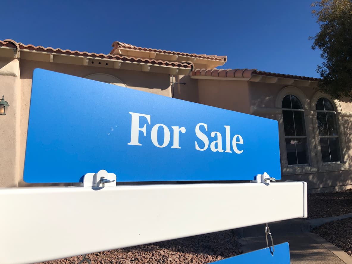 Blue for sale sign in front of house