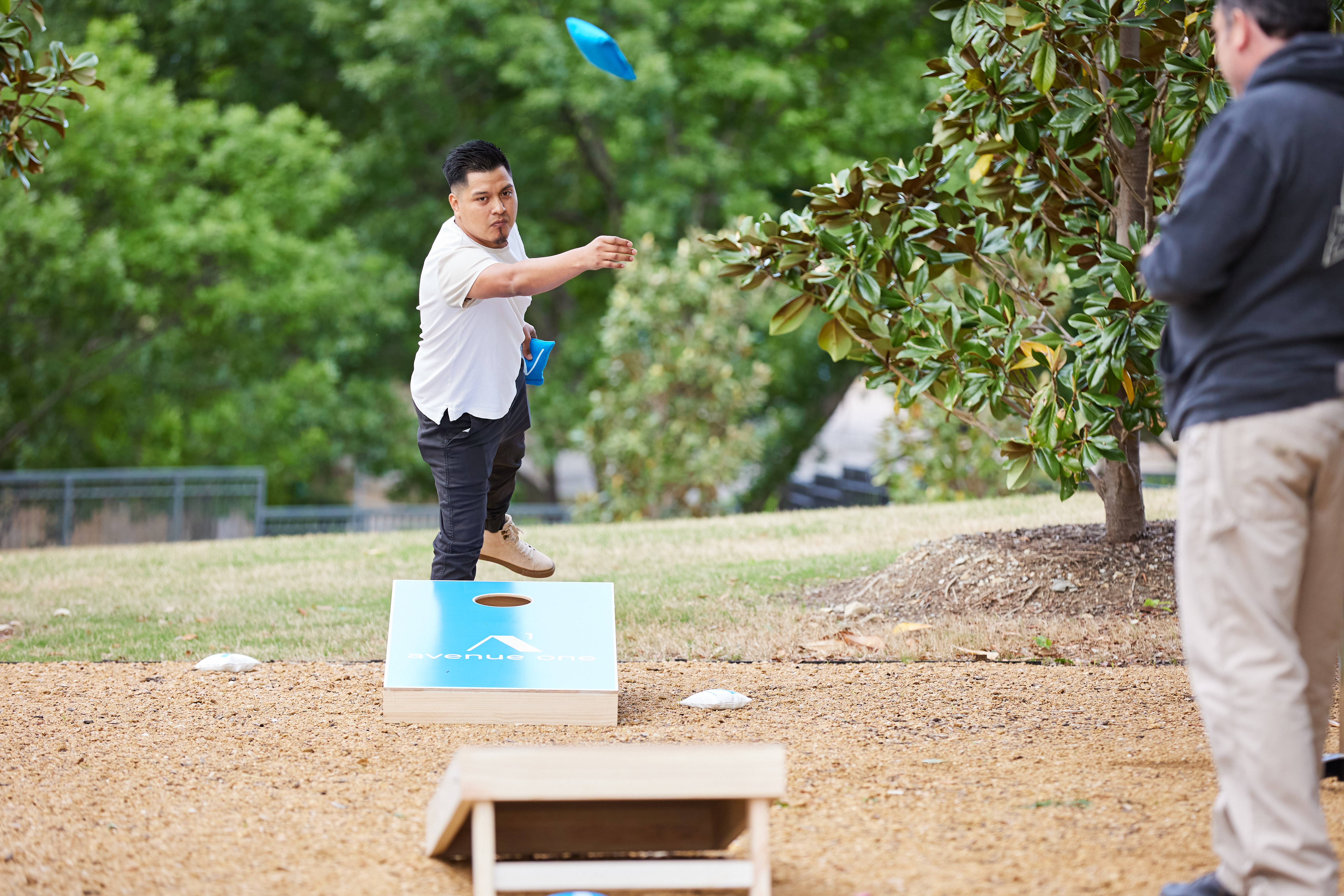 Man playing cornhole and throwing a cornhole bag