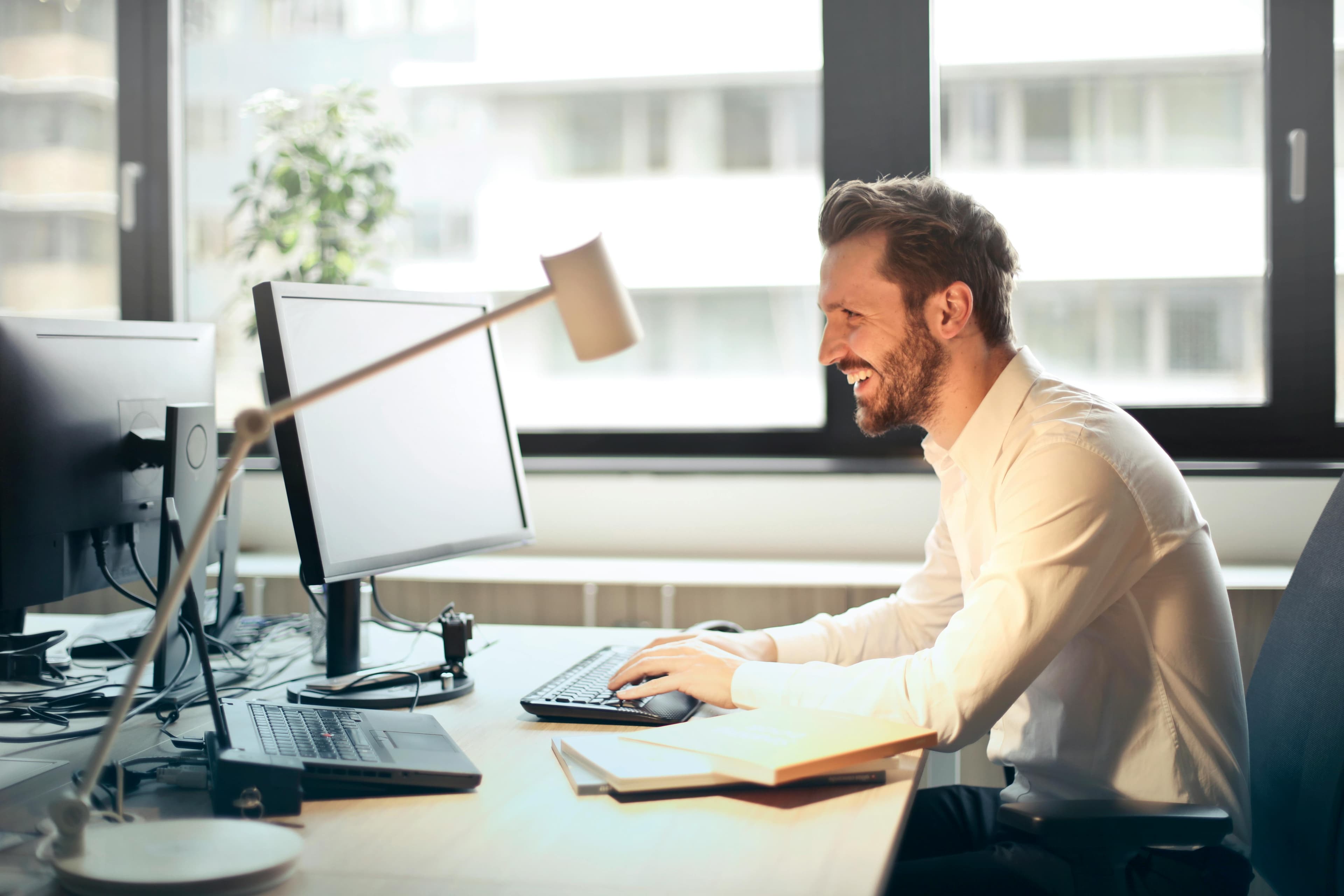 Man sitting at a desk typing on a desktop
